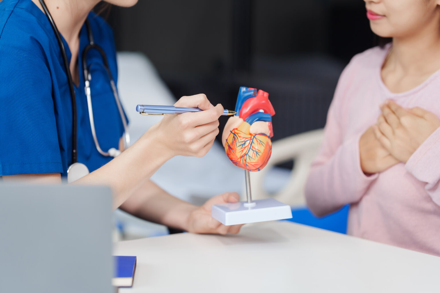 Image Cardiology clinic, young Caucasian female doctor explains heart
